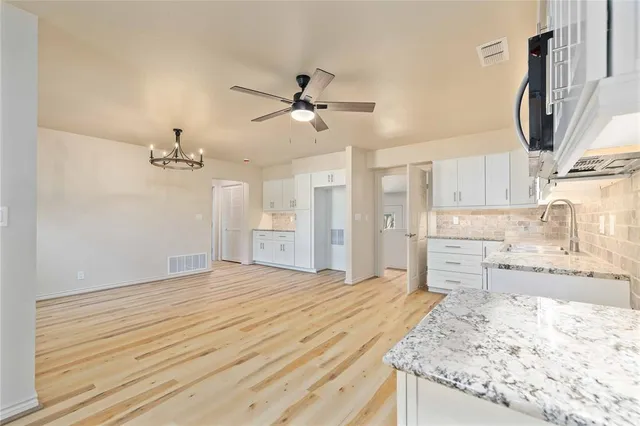 a bathroom with a granite countertop sink a mirror and a shower