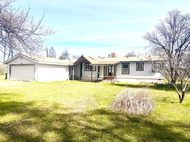 a front view of house with yard and swimming pool