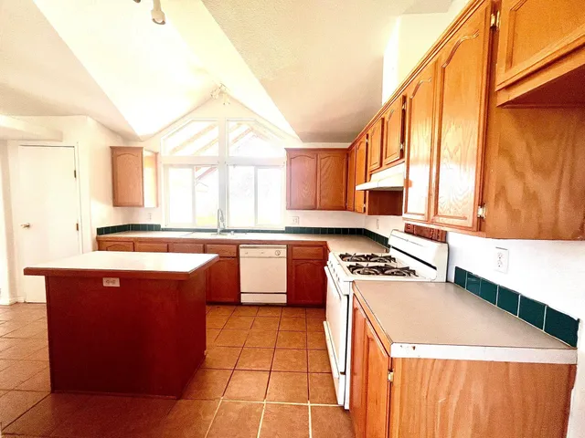 a kitchen with stainless steel appliances granite countertop a stove a sink dishwasher and a refrigerator