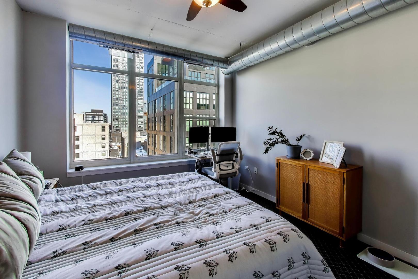 909 West Washington Boulevard, Unit 811 Chicago, IL 60607 - Photo 13 of 28 a bedroom with a bed and wooden floor