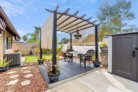 a view of a chair and table in backyard of the house