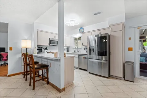 a kitchen with appliances cabinets and chairs