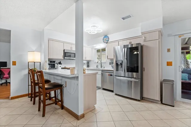 a kitchen with appliances cabinets and chairs