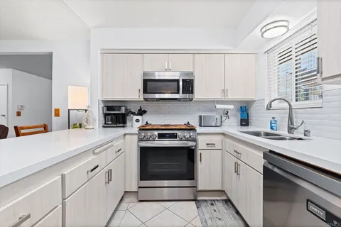 a kitchen with cabinets stainless steel appliances and a sink