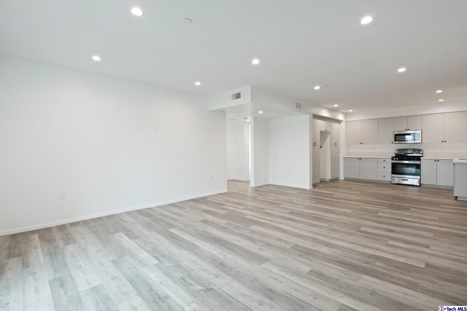 7064 Greeley Street, Unit 101 Tujunga, CA 91042 - Photo 17 of 37 a view of kitchen with kitchen island a sink wooden floor and appliances