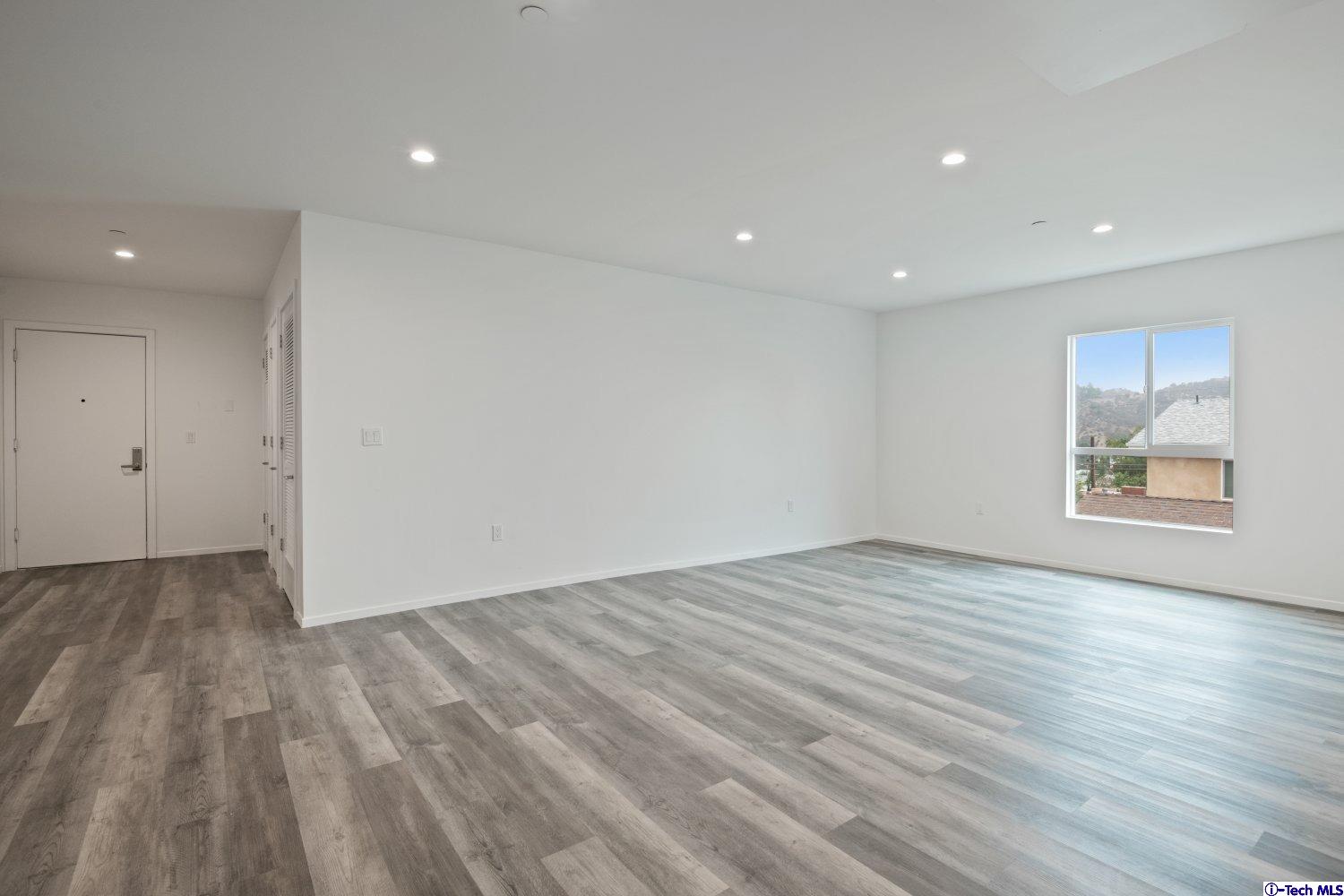 7064 Greeley Street, Unit 101 Tujunga, CA 91042 - Photo 19 of 37 a view of an empty room with wooden floor and window