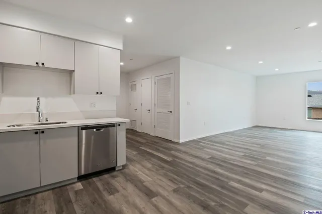 a kitchen with kitchen island white cabinets appliances and a sink