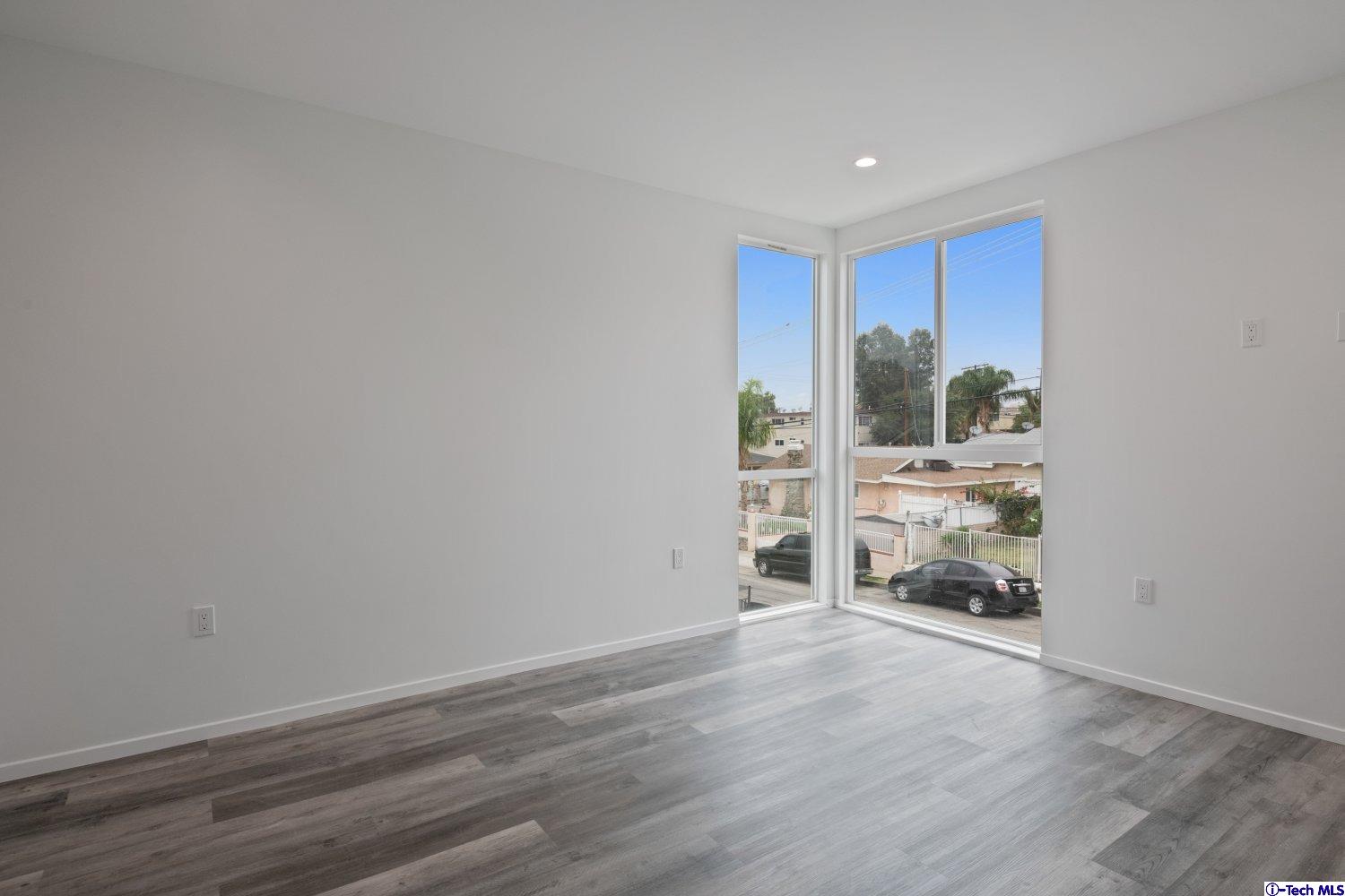 7064 Greeley Street, Unit 101 Tujunga, CA 91042 - Photo 25 of 37 a view of an empty room with a window and wooden floor