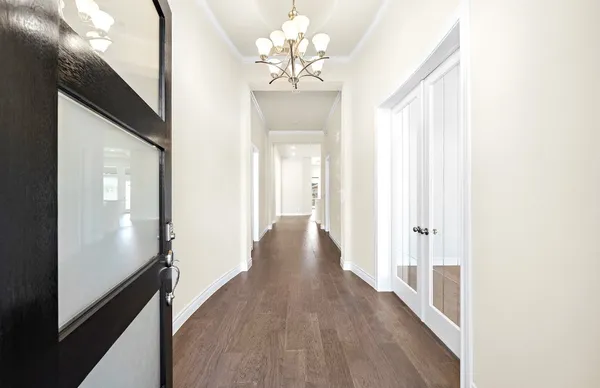 a view of a hallway with wooden floor