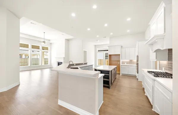 a kitchen with kitchen island a stove a table and chairs in it