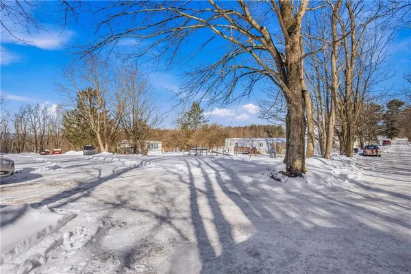 a view of a yard covered with snow in front of house
