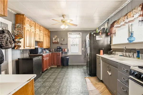 a kitchen with a refrigerator a sink a stove top oven and cabinets