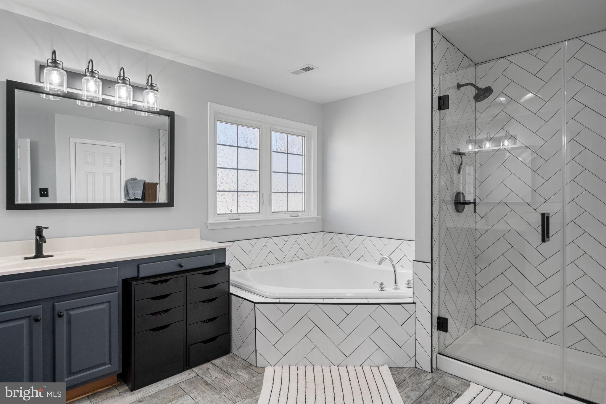 4016 Sapling Way Triangle, VA 22172 - Photo 29 of 56 a bathroom with a tub sink and mirror