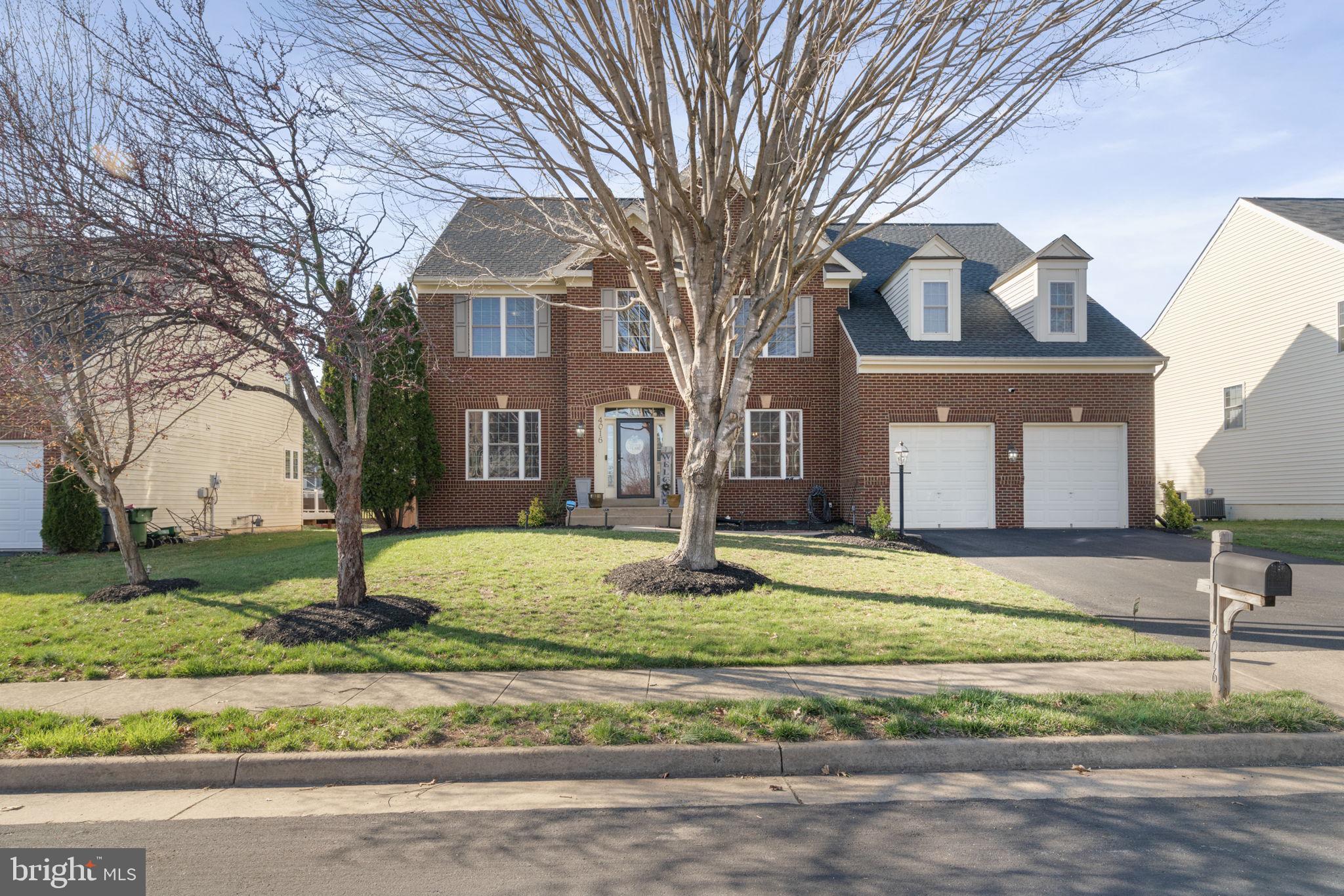 4016 Sapling Way Triangle, VA 22172 - Photo 5 of 56 a front view of a house with garden and trees