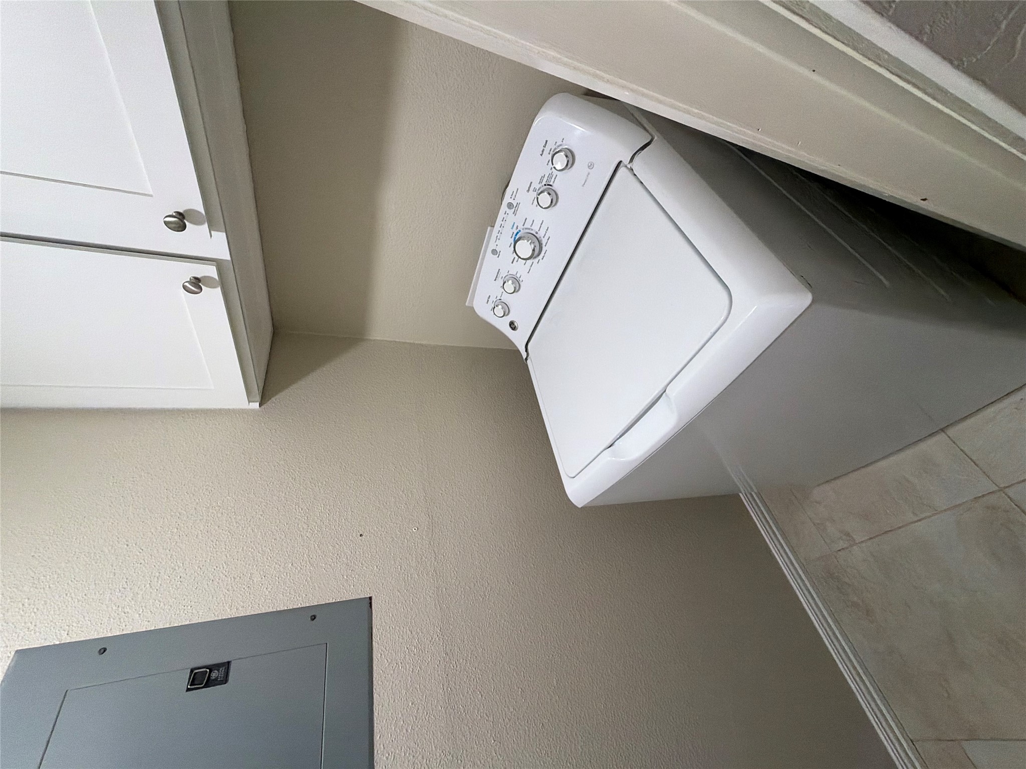 1401 Camp Craft Road, Unit C Austin, TX 78746 - Photo 5 of 12 Functional utility space featuring a washer and convenient overhead storage cabinetry.