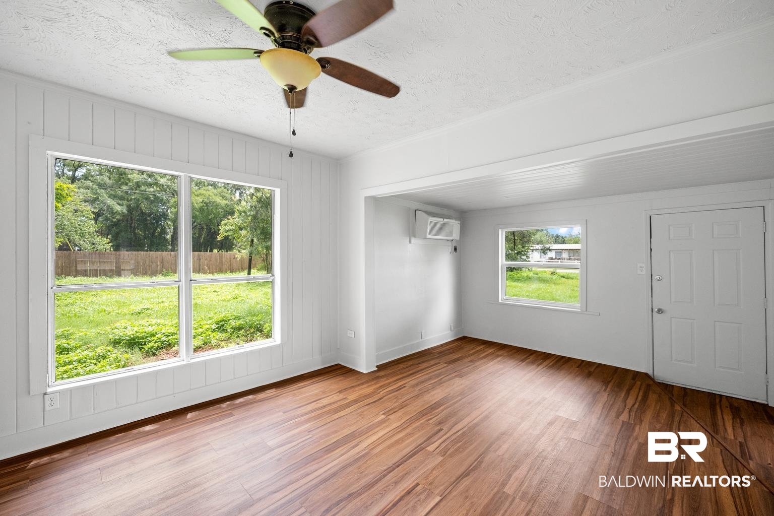 19575 Keller Road Foley, AL 36535 - Photo 7 of 17 Unfurnished room with wood finished floors, a ceiling fan, a textured ceiling, and wooden walls