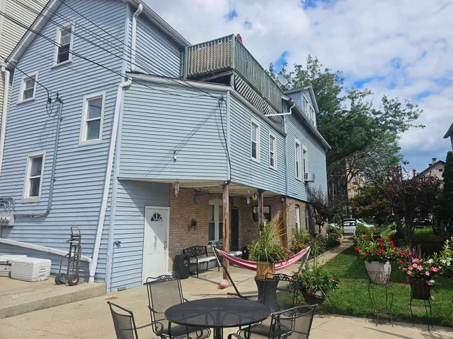 a view of a chair and tables in backyard of the house
