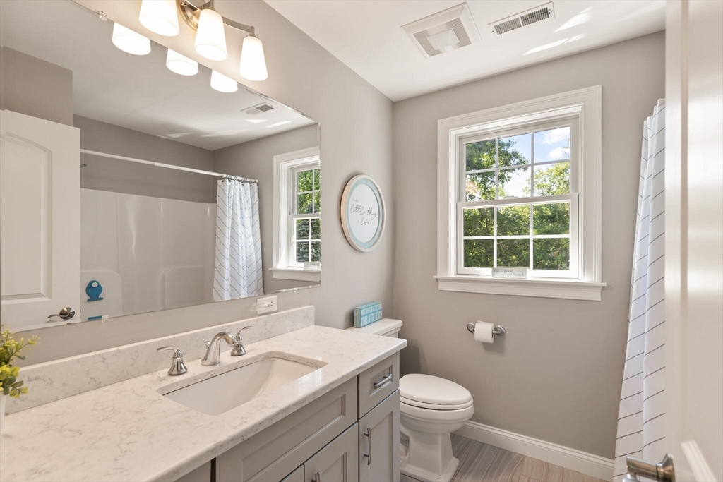 2 Leitner Way Middleton, MA 01949 - Photo 15 of 42 a bathroom with a toilet a sink a mirror and a window