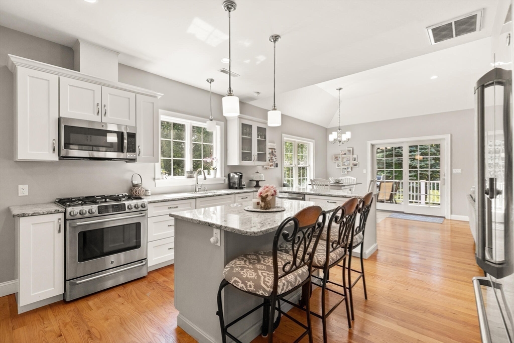 2 Leitner Way Middleton, MA 01949 - Photo 25 of 42 a kitchen with stainless steel appliances granite countertop a stove a sink a microwave a dining table and chairs