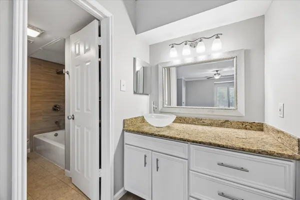 a bathroom with a granite countertop sink and mirror