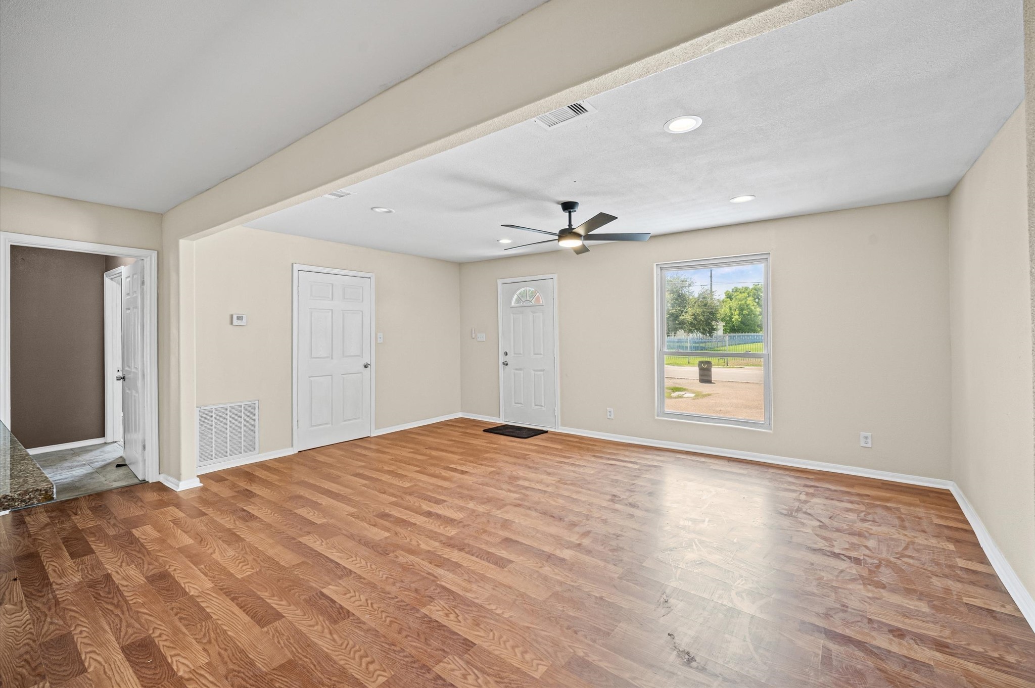 10621 Lane Street Houston, TX 77029 - Photo 5 of 29 a view of an empty room with wooden floor and a window