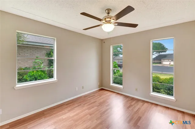 a view of an empty room with window wooden floor and a window