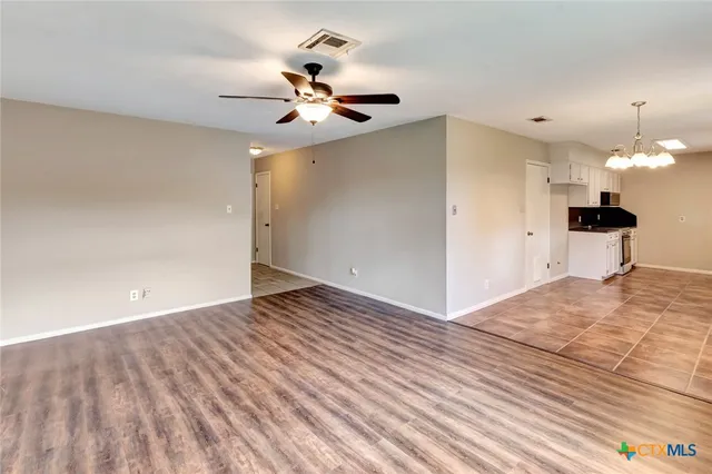 a view of a room with wooden floor and a ceiling fan