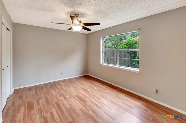 a view of an empty room with wooden floor