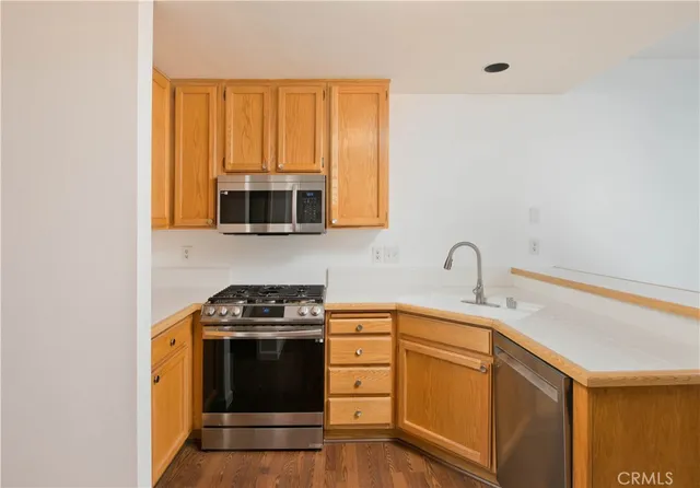 a kitchen with sink a microwave and cabinets