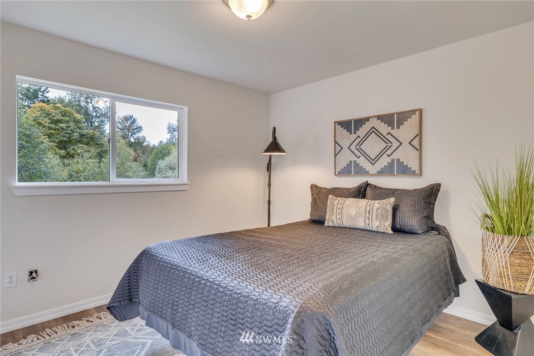 20260 Maxwell Road Southeast Maple Valley, WA 98038 - Photo 17 of 38 a bedroom with a large bed and a painting on the wall