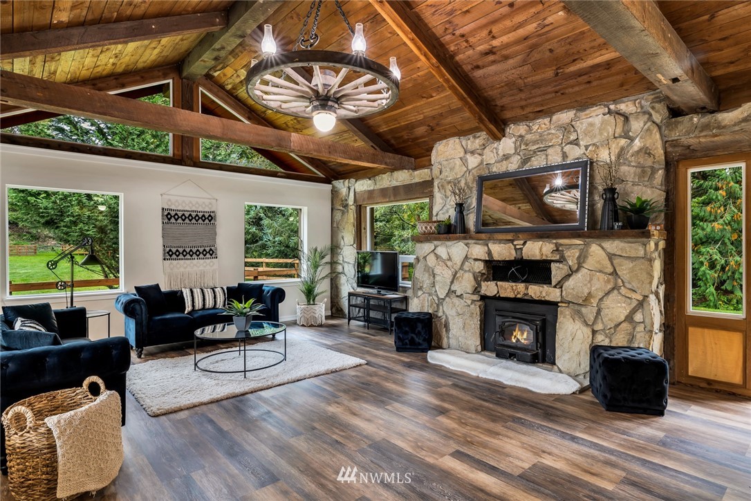 20260 Maxwell Road Southeast Maple Valley, WA 98038 - Photo 5 of 38 a living room with furniture a fireplace a flat screen tv and a large window