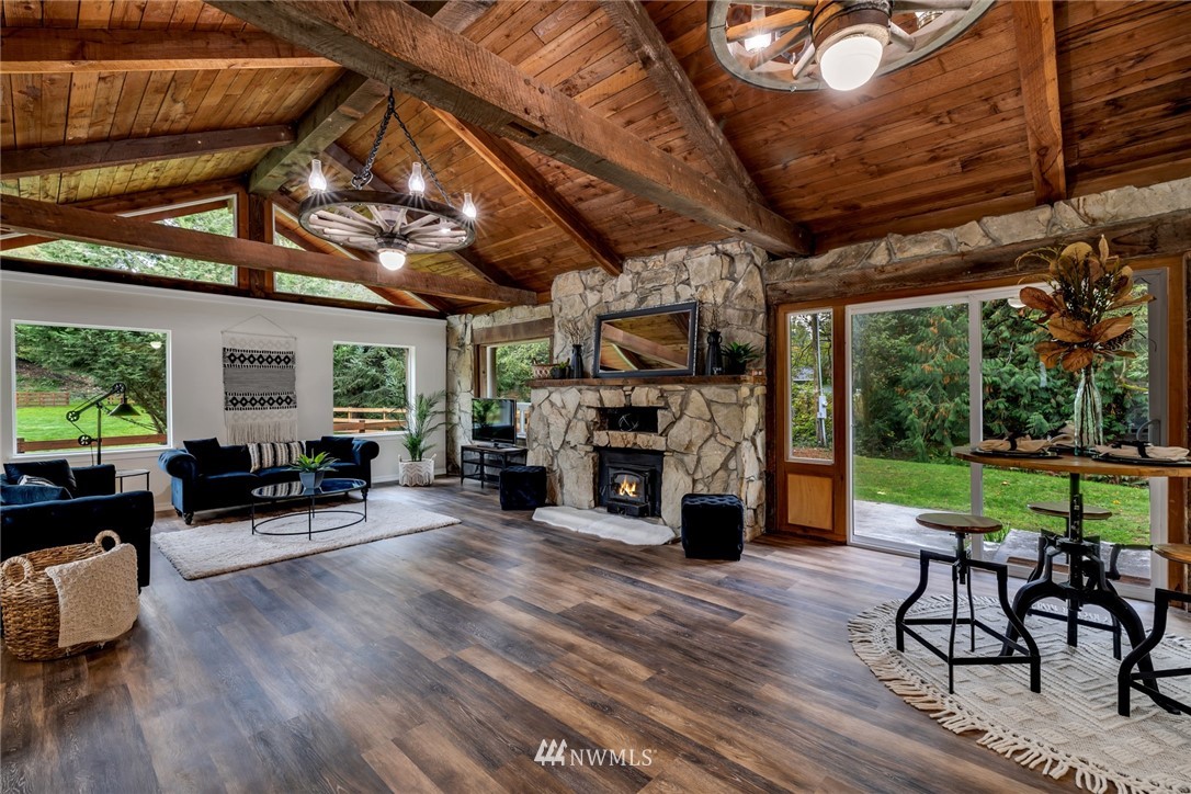 20260 Maxwell Road Southeast Maple Valley, WA 98038 - Photo 6 of 38 a view of a patio with table and chairs a barbeque with wooden floor and roof with potted plants