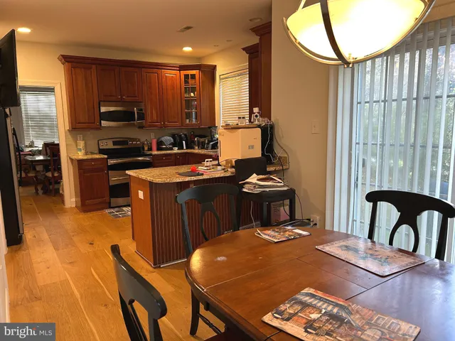 a kitchen with a stove a sink a microwave a dining table and chairs