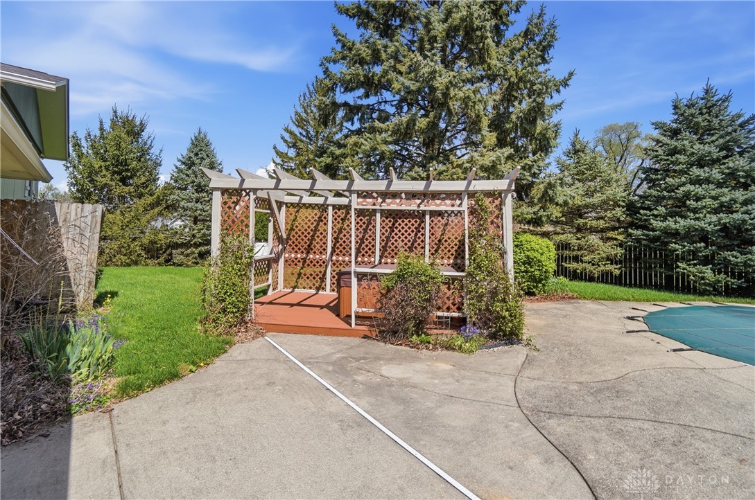 9964 Hummingbird Way Dayton, OH 45458 - Photo 50 of 57 An inviting backyard oasis features a charming pergola, lush lawn, and mature trees, perfect for outdoor enjoyment.