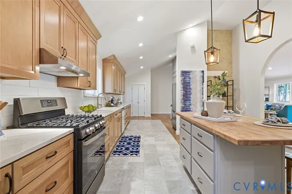 a kitchen with stainless steel appliances granite countertop a sink stove and cabinets
