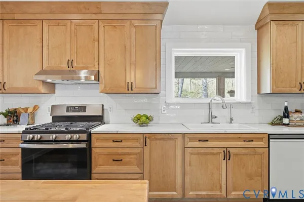 a kitchen with granite countertop a sink stainless steel appliances and cabinets