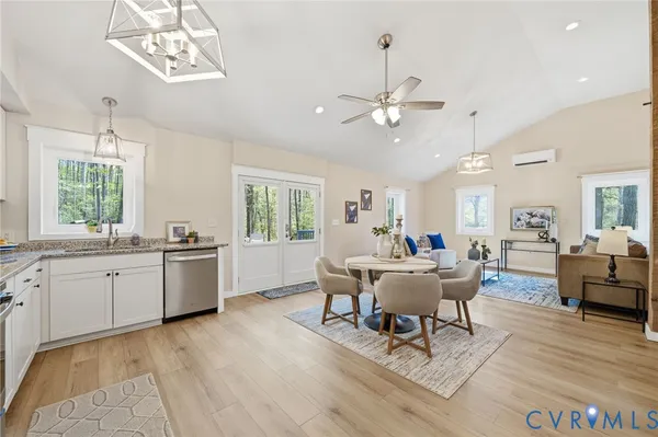 a living room with furniture two window and wooden floor