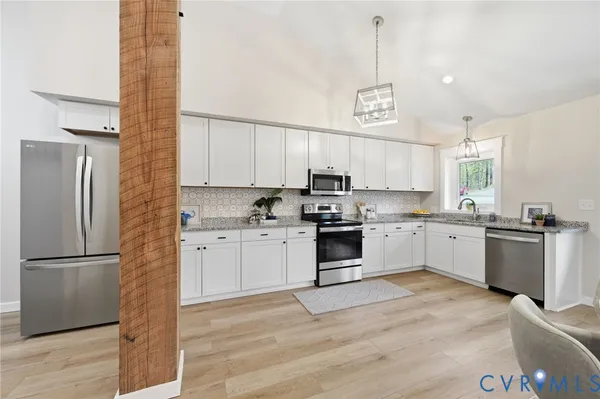 a kitchen with a refrigerator cabinets and wooden floor