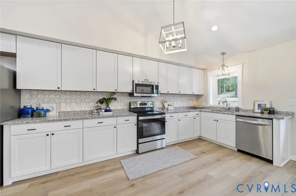 a kitchen with granite countertop white cabinets and white appliances