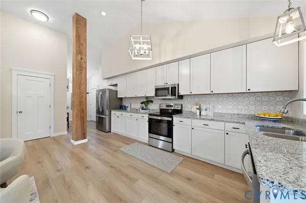 a kitchen with granite countertop a stove a sink and a refrigerator