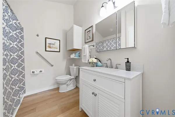 a bathroom with a granite countertop toilet sink and mirror