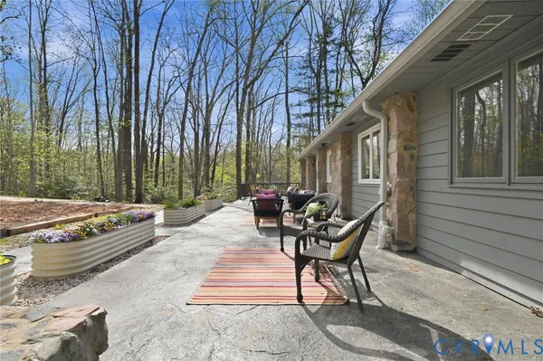 a view of a patio with a table and chairs and wooden fence