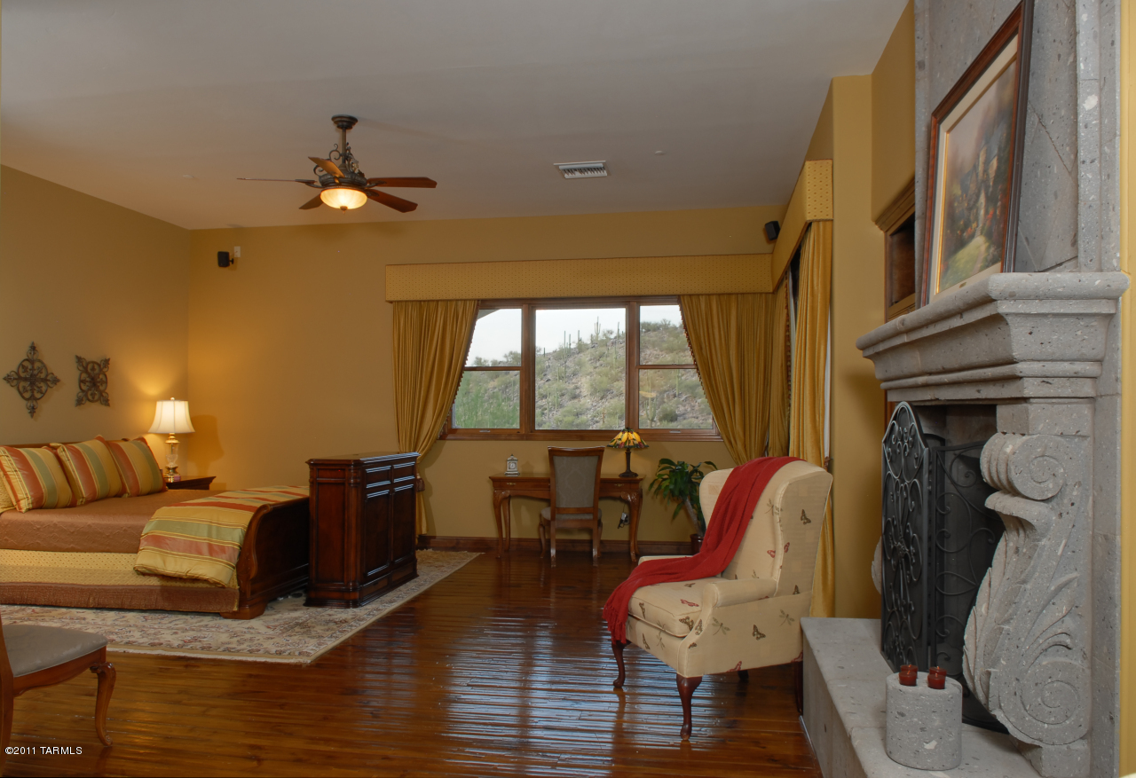 2188 East Buck Ridge Place Oro Valley, AZ 85737 - Photo 13 of 22 a living room with furniture a fireplace and a large window
