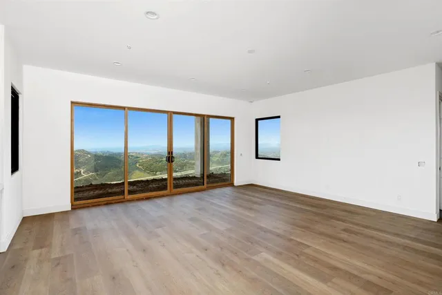an empty room with sliding door and wooden floor