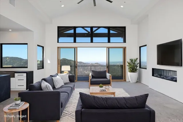 a living room with furniture a flat screen tv and a floor to ceiling window