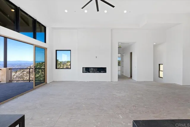 a view of an empty room with a window and fireplace