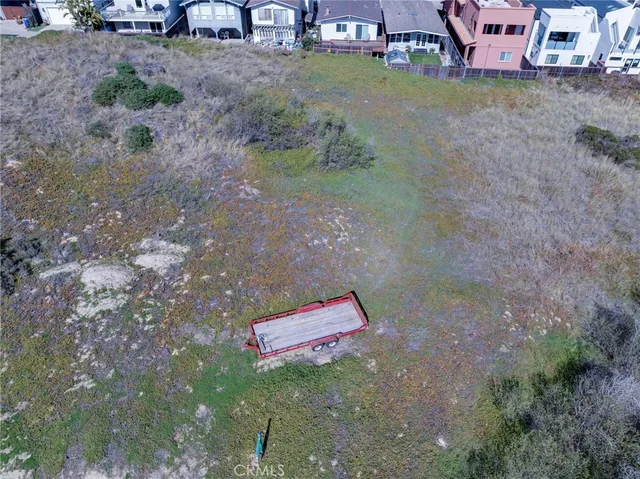 a view of a dry yard with wooden fence