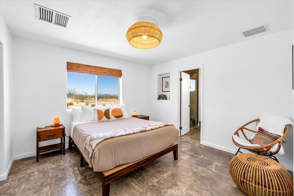 59700 Napa Road Landers, CA 92285 - Photo 22 of 68 a bedroom with a bed and a chandelier