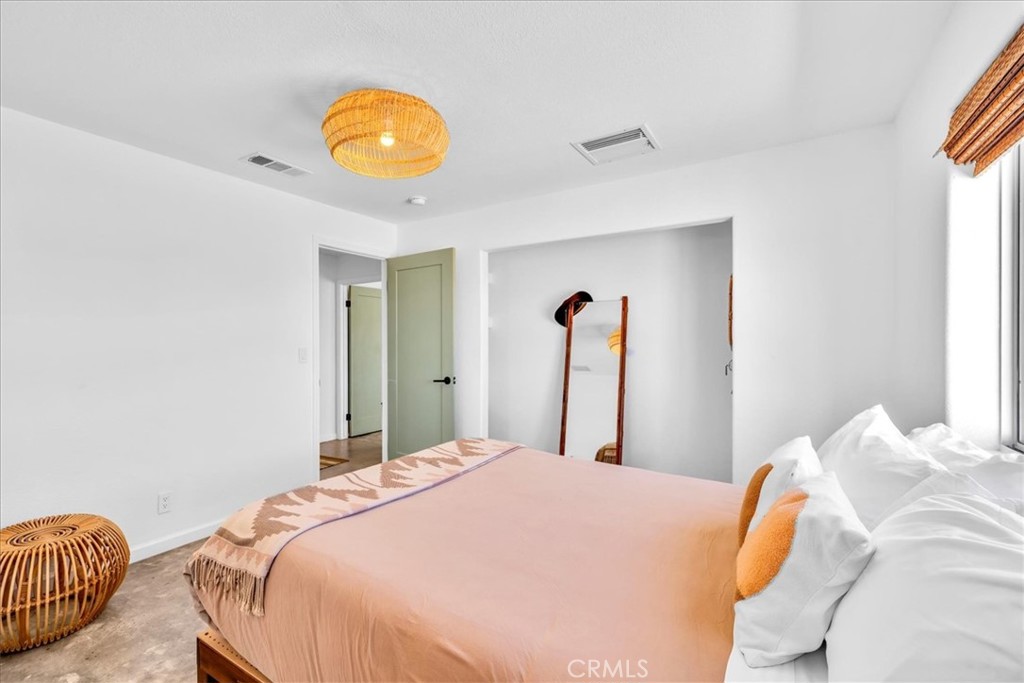 59700 Napa Road Landers, CA 92285 - Photo 23 of 68 a bedroom with a bed and a chandelier