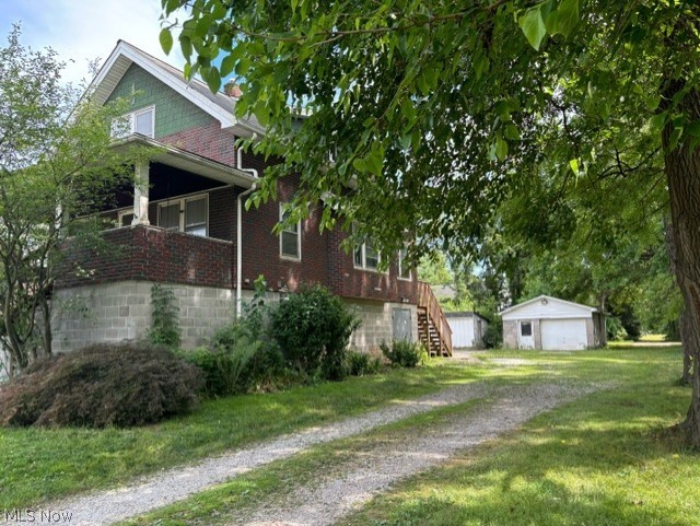 8526 Fosdick Road Cleveland, OH 44125 - Photo 3 of 25 View of side of home featuring a garage, 2 outbuilding, and a yard